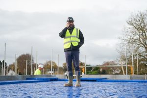 Man standing on branded safety decking on the phone